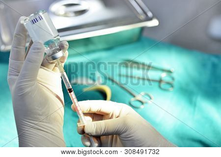 Hand Holding Syringe And Medicine Vial Prepare For Injection With Surgical Equipment And Medicine Vi