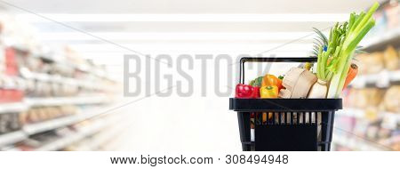 Black Shopping Basket Full Of Food And Groceries In Suppermarket Aisle Banner Background With Copy S