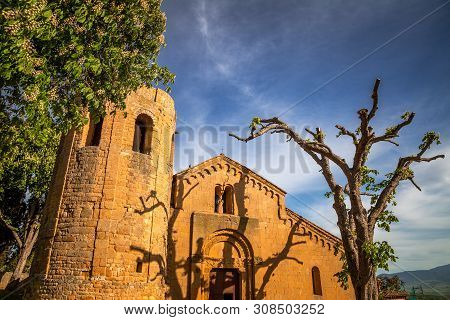 The Shadows Of A Tree At A Setting Sun On A Facade Of La Pieve Di Corsignano, An Enchanting Church N
