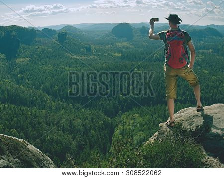 Phone Photographer. Man Tourist On The Edge Take Phone Pictures.  Hker In Leather Hat, T-shirt, Shor