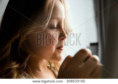 Interaction Of Children With Adult World. Cute Girl Trying To Do Bright Make Up For Being Older. Lit