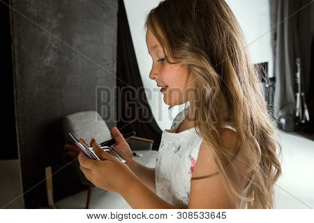 Interaction Of Children With Adult World. Cute Girl Trying To Do Bright Make Up For Being Older. Lit