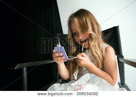 Interaction Of Children With Adult World. Cute Girl Trying To Do Bright Make Up For Being Older. Lit