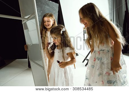 Interaction Of Children With Adult World. Cute Girls Trying To Do Bright Make Up For Being Older. Li