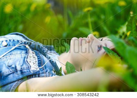 Woman Listening To Music With Headphones At The Park