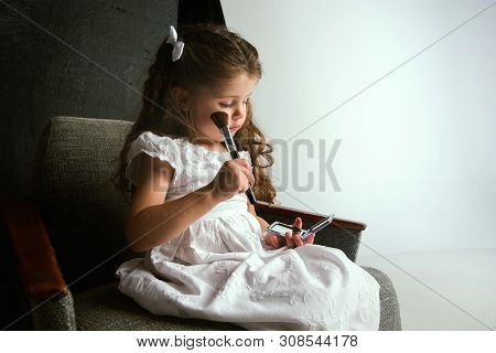 Interaction Of Children With Adult World. Cute Girl Trying To Do Bright Make Up For Being Older. Lit