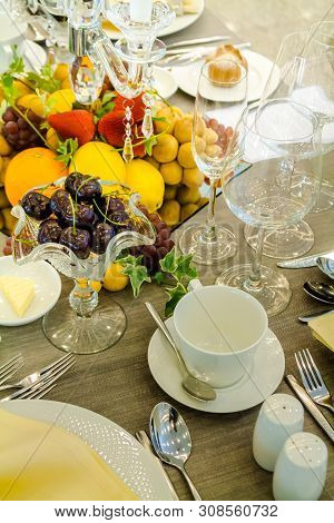 Party Dinner Table Setting With Tableware And Silverware And Glasses Set And Candlestick And Flower 