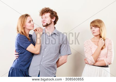 Jealousy And Betrayal Concept. Abandoned Jelous Girl Watching On Happy Hugging Couple. Triangle Rela