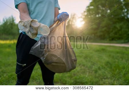 Blogging Concept. A Man Collects Trash From The Forest In The Trash Bag