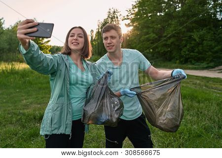 Friends Crouching With Bag Picking Up Trash Doing Plogging.plogging Concept. Boy And Girl Picking Up