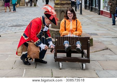 Chester, Uk - 26th June 2019: The Town Crier Locks Up A Tourist In A Stockade In The Middle Of The C
