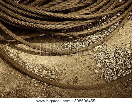 Old Rusty Strong Cable Rolled Into The Bay. The Rings Of Iros Are Located On The Ground, The Yard Of