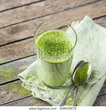 Glass Of Matcha Green Tea Latte On A Wooden Table