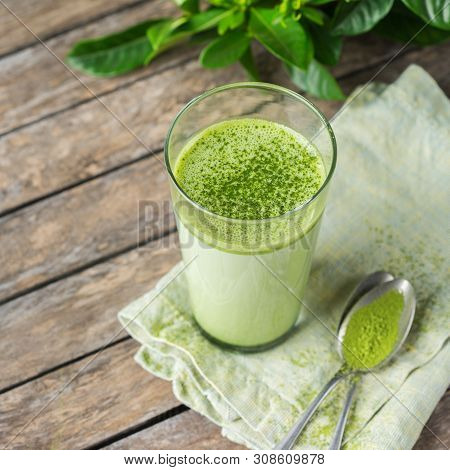 Glass Of Matcha Green Tea Latte On A Wooden Table