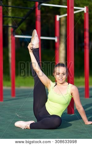 Stretching Danser Or Gymnast Woman Training Trains In Workout Sports Ground. Good Stretching, Twine,