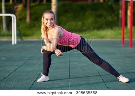 Portrait Of Fit And Sporty Young Woman Doing Stretching In Workout Sports Ground