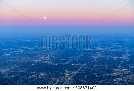 Scenic aerial view of fuul moon setting over Chicago, IL suburbs