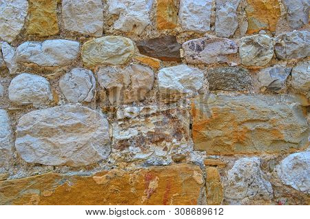 Background Of Many Rough Colored Stones Of The Old Wall Closeup
