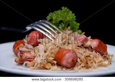 German, Polish, Austrian Cuisine Dish, Bigos - Cabbage Stewed With Meat And Sausages On A White Plat