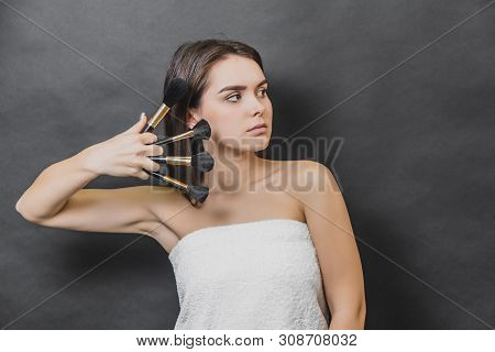 Portrait Of Young Gorgeous Girl With Four Makeup Brushes. She Is Looking Leftwards.