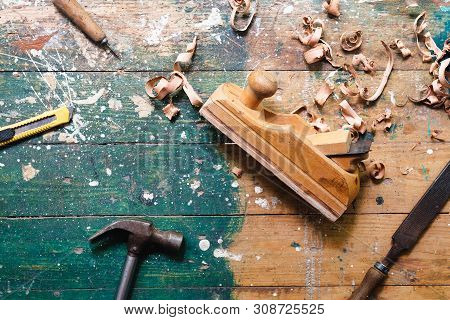 Flat Lay Set Of Vintage Carpentry Tools On Colorful Wooden Background. Top View Workbench With Carpe