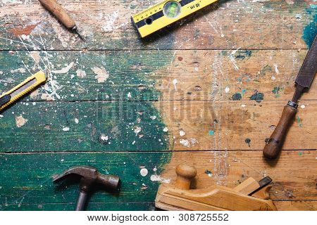 Flat Lay Set Of Vintage Carpentry Tools On Colorful Wooden Background. Top View Workbench With Carpe