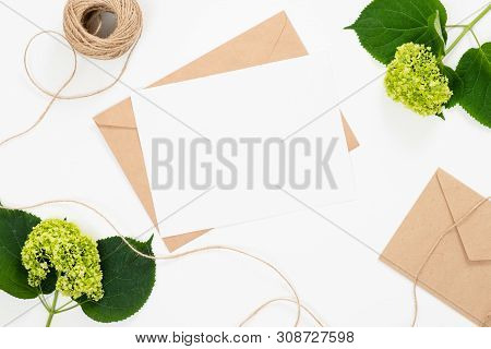 Flat Lay Fashion Office Desk. Female Workspace With Blank Paper Card, Craft Envelope, Green Flower B