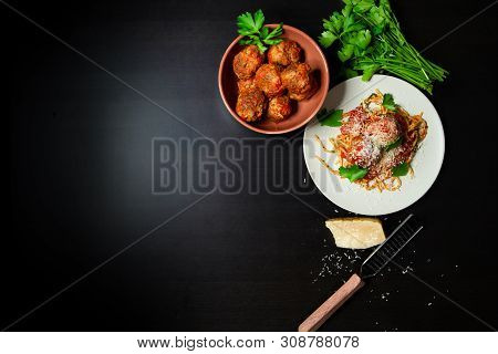 An Overhead Shot Of A Plate Of Rustic Spaghetti And Meatballs With A Bowl Of Meatballs, Parmesean Ch