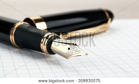 Golden Fountain Pen On The Notepad On A Table Closeup
