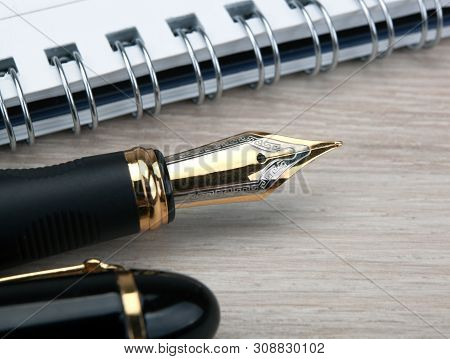 Fountain Pen Near The Notepad On A Wooden Table  Closeup