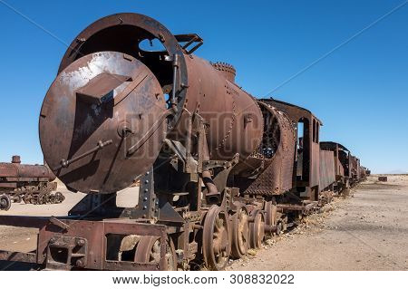 A View Along The Side Of A Rusting Steam Train And Carriages Slowly Rot Away At The Train Graveyard 