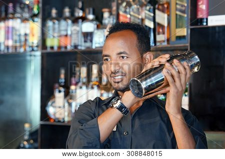 Professional African Bartender Male Holding In Hands A Shaker With A Fresh Delicious Cocktail. Barte
