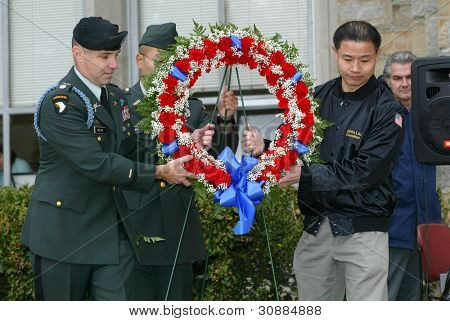 NEW YORK - 11. listopadu: NYC radní John Liu (R) pomáhá americký voják jistotu věnec na veterána