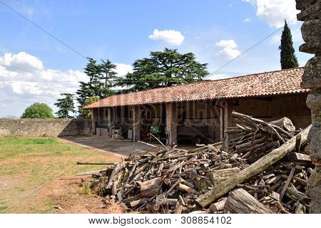 The Wood Piled In The Storage Yard Of An Old Farmhouse In Franciacorta - Italy