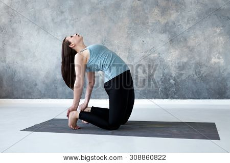 Woman Practicing Yoga, Doing Ushtrasana, Camel Pose, At Studio Full Length.