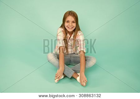 Find Place To Relax. Girl Happy Face Sit On Floor Attentive Looking At Camera Turquoise Background. 