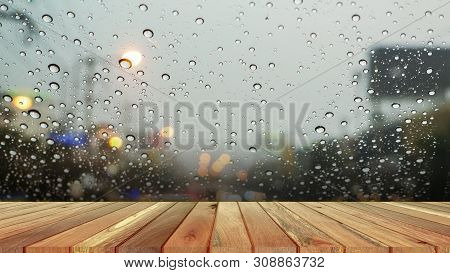 Wood Plank With Abstract Water Drop On Glass Background Of Glass Window Shop On A Rainy Day. Free Pl