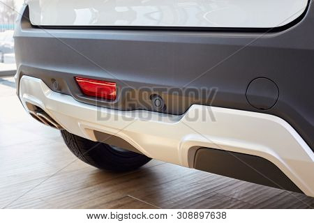 Parking Sensors On A White Car, Rear Bumper With Reflector And Exhaust Pipe And Place To Install The