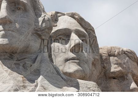 Sunshine And White Clouds Provide A Striking Back Drop For Three Of The Carved Faces Of Famous Unite