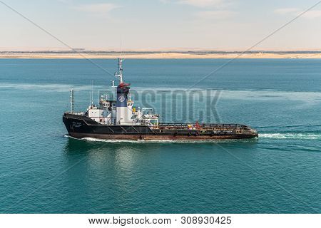 Suez, Egypt - November 5, 2017: Tug Ezzat Adel Vessel Passing The New Suez Canal Near The Great Bitt