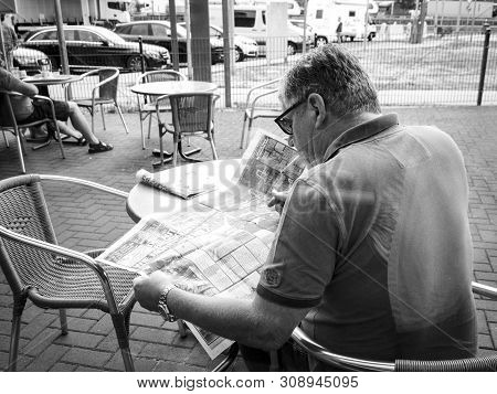 Stuttgart Germany - Aug 15 2018: Black And White Image Of Rear View Of Senior Man Reading Die Bild N