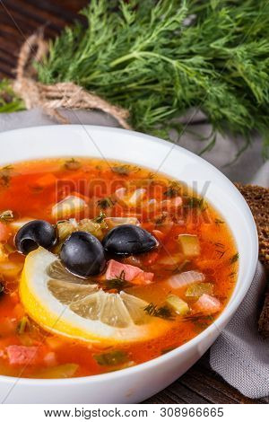 Traditional Russian Meat Soup Solyanka In Bowl On Rustic Wooden Table