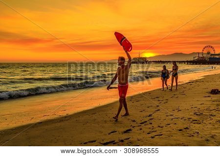 Santa Monica, California, Usa - August 8, 2018: Surf Rescue Baywatch Lifeguard With Lifesaver At Sun