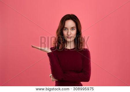 Excited Young Lady Standing Isolated Over Dark Pink Background Looking At You With A Palm Of A Hand 
