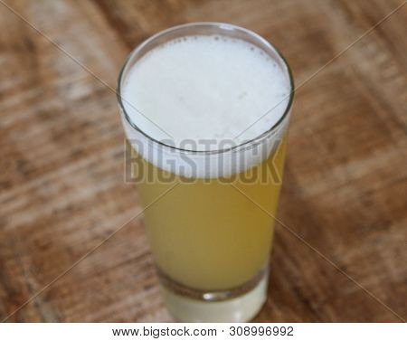 Close Up Of Glass Filled With Radler, Mixture Of Beer And Sparkling Lemonade, On Wooden Background