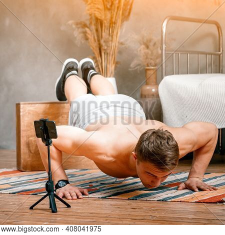 A Young Man Shoots A Video, A Sports Blog At Home. The Athlete Shows How To Do Push-ups Correctly, F