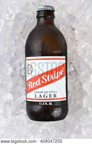 IRVINE, CA - JANUARY 11, 2015: A bottle of Red Stripe Jamaican Style Lager on a bed of ice. Brewed in Jamaica since 1938 by Desnoes and Geddes its international distribution is handled by Diageo.