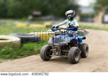 A Child Rides An Atv On The Track