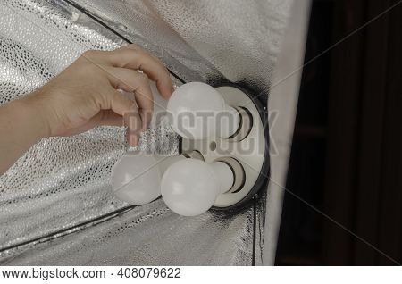 Man's Hand Screws Special Electric Lights Into The Softbox Holder. Studio Lighting Assembly Sequence