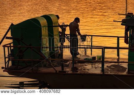 Monywa, Myanmar - December 22, 2019: View Of A Man Taking A Shower On His Boat Before Going To Home.
